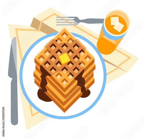 A tasty breakfast of waffles with butter and syrup, served with a glass of chilled juice.