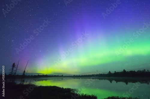 Wallpaper Mural Northern lights in vast starry sky reflecting in misty lake water Torontodigital.ca