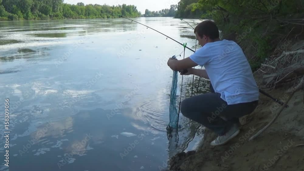 The fisherman photographs the fish on a smartphone for placement in social networks. A man takes pictures of his catch for instagram.