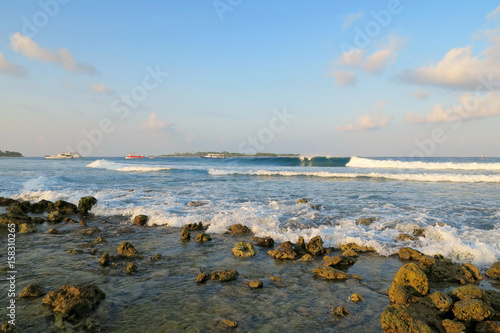 Jailbreaks surfing spot with waves in evening on Himmafushi island, Maldives photo