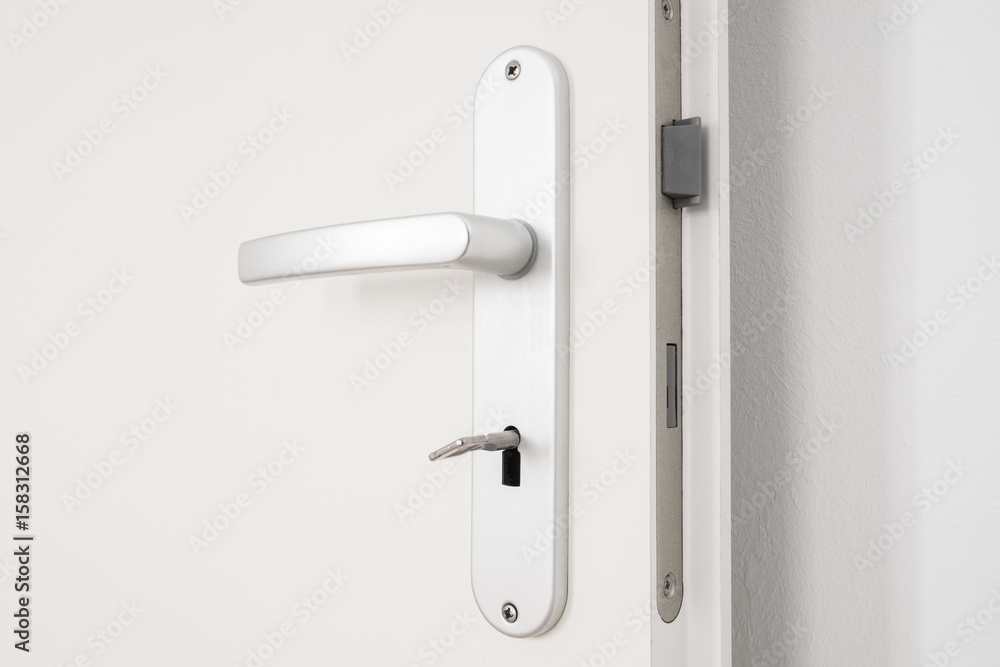 Fototapeta premium metallic door handle with key on white door
