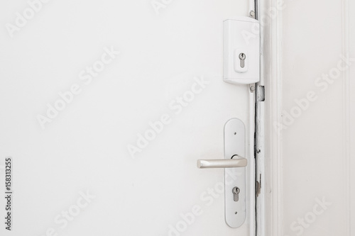  door handle and bar lock on white apartment door