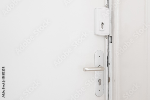  door handle and bar lock on white apartment door photo