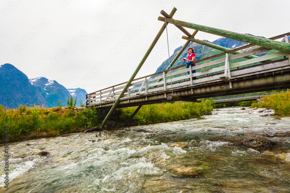 Tourist relaxing on bridge in village Oppstryn Norway Tourist relaxing on bridge in village Oppstryn Norway