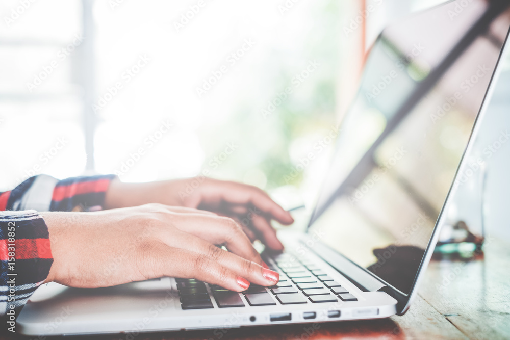 Hipster lifestyle - Close Up shot of business asian female hands typing on laptop keyboard, woman working at coffee shop or office and using modern computer keyboard. vintage color tone Hipster lifestyle - Close Up shot of business asian female hands typing on laptop keyboard, woman working at coffee shop or office and using modern computer keyboard. vintage color tone