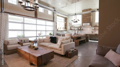 Modern Open Living Space with Kitchen Rising Right Angle. a rising shot of a unique modern rustic industrial living open floor plan living space with kitchen and high ceilings and patio garage door
