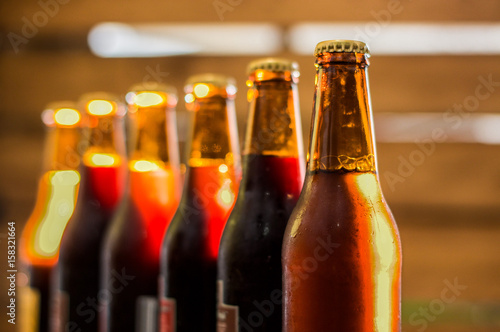 Wet bottles of craft beer on blurred background