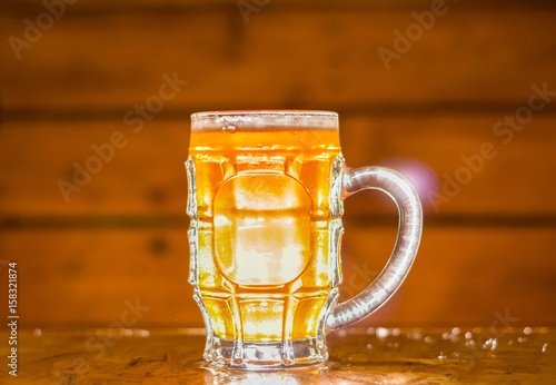 Close up of a blonde craft beer filled into a pint glass on wooden background photo