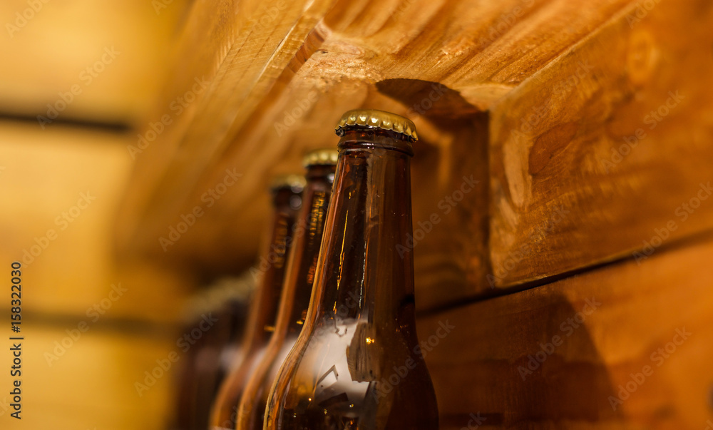 Naklejka premium Close up of bottles of craft beer on wooden background