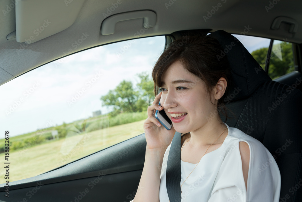 young woman calling with smart phone in motor vehicle.