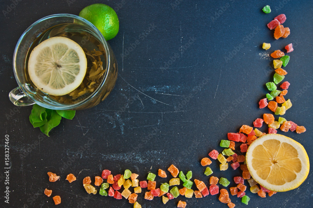 Lemon, lime and a few candied fruits on a black board. Back background of black board and fruits. Frame, decoration.
Lemon, lime and a few candied fruits on a black board. Back background of black board and fruits. Frame, decoration.