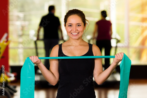 Girl using a resistance band in her exercise routine. Woman fitness elastic excercises