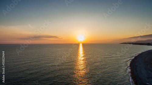 sunset over water surface of the sea from the height of bird flight