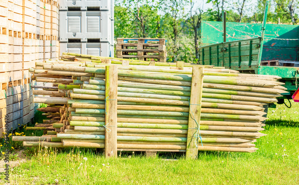 Stack of impregnated wooden fence posts on a pallet. Posts have been used so there is soil still on the sharpened ends. Stack of impregnated wooden fence posts on a pallet. Posts have been used so there is soil still on the sharpened ends.