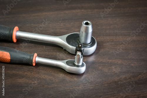 ratchet wrench lying on wooden table