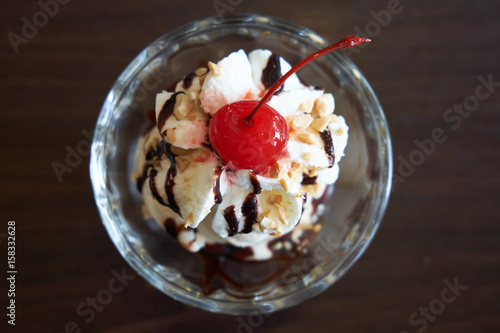 Ice cream chocolate and vanilla sundae topping with red cherry. Top view. photo