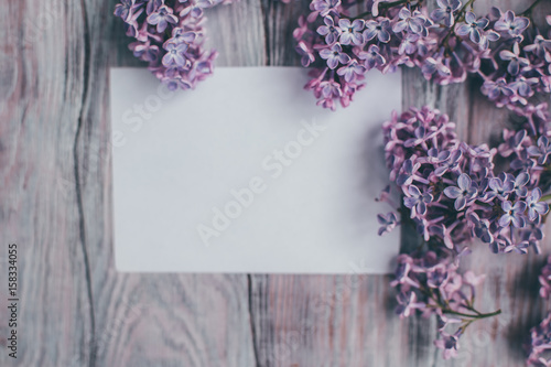 Creative layout is made with lilac with paper card note.Nature concept.Flat lay.