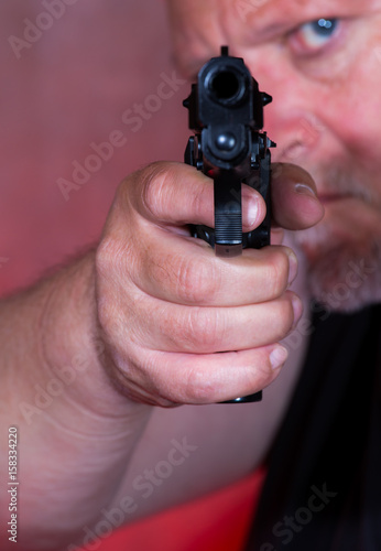 A man holds a pistol in his hand