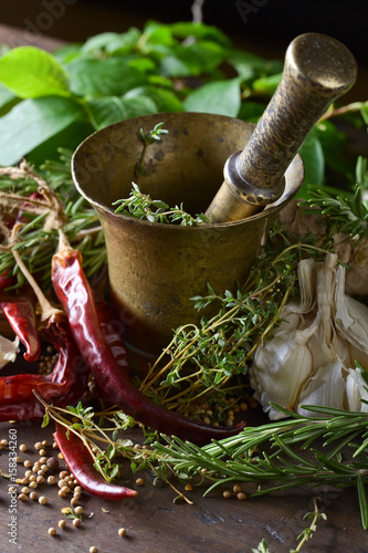 Different herbs and spices on a wooden table .