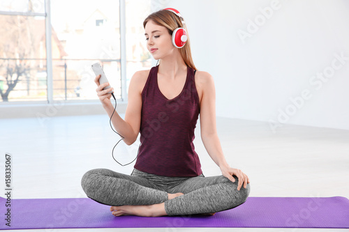 Woman doing yoga and listen...