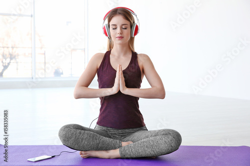 Woman doing yoga and listen...