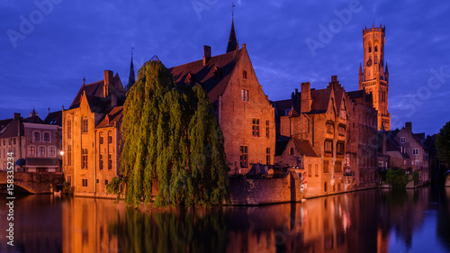 Bruges, Belgium. Famous photo spot "Huidenvetters plein", Dijver river canal twilight and Belfort (Belfry) tower.