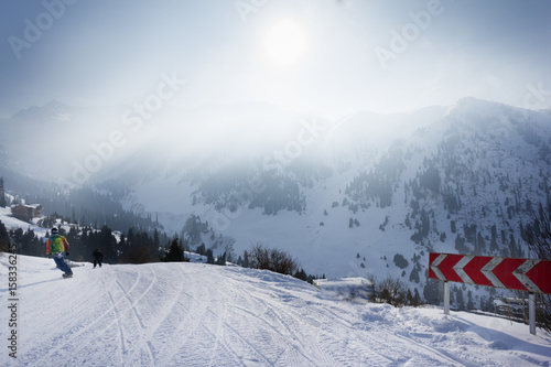 dangerous turn for snowborders in the mountains. magic sun shining through the clouds © Mak