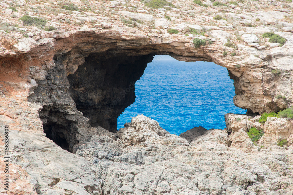 Natural arch in Blue Lagoon at Comino island in Malta.