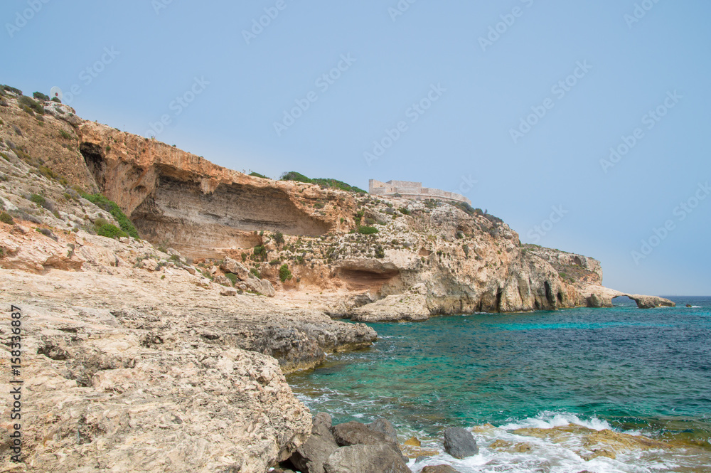 Rocky coastline with Saint Mary's Battery in Comino Island in Malta.