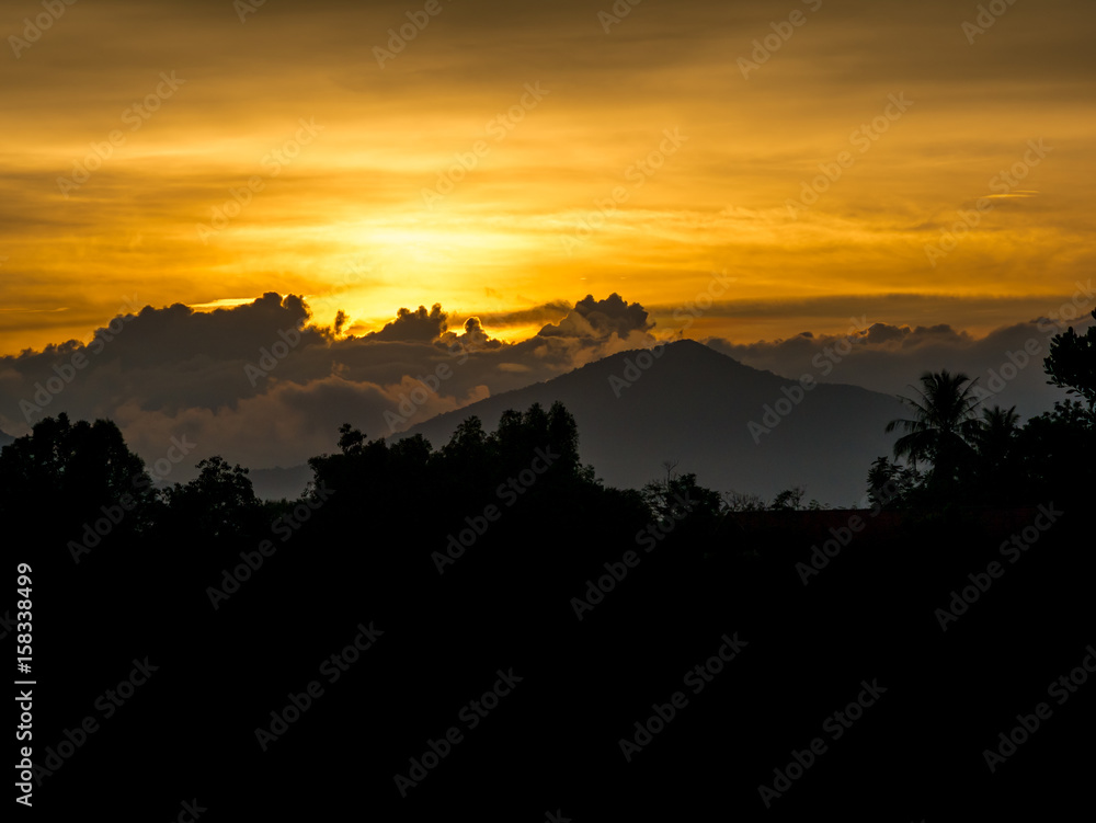 Sunset behind cloud and mountain