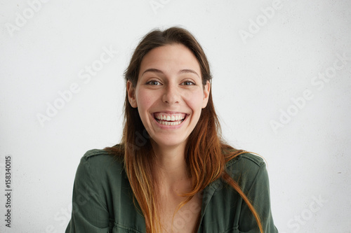 Cheerful good-looking Caucasian female student looking sincerely having pleasant smile being happy to pass her exams successfully. Happy woman enjoying her life. Positive emotions and feelings. © wayhome.studio 