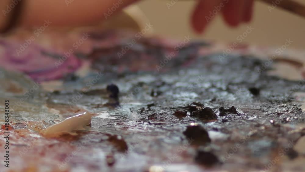 Artist interferes paint on the palette Artist interferes paint on the palette