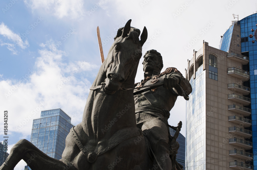 Fototapeta premium Russia, 27/04/2017: lo skyline di Mosca e il monumento al Comandante Bagration, generale russo di origine georgiana, in un giardino pubblico su via Kutuzovsky Prospect