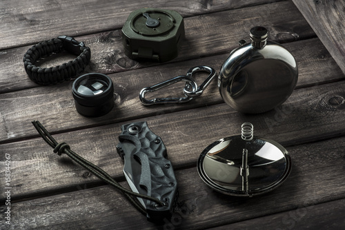 hiking travel gear on wood backdrop. Flat lay of outdoor travel equipment items for mountain camping trip..