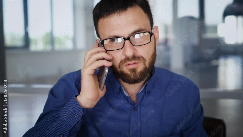 An adult man and a young woman are negotiating with an investor on a mobile phone, the lady records the information received in a notebook An adult man and a young woman are negotiating with an investor on a mobile phone, the lady records the information received in a notebook