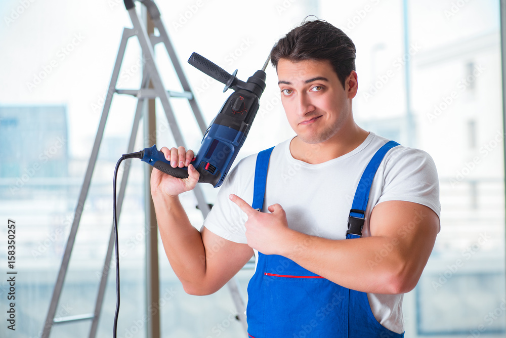 Young worker with hand drill Young worker with hand drill