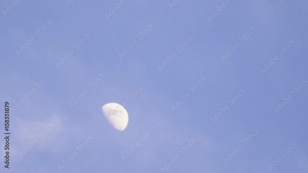 Daytime Moon with passing clouds slowly in tiemalapse shot. Daytime Moon with passing clouds slowly in tiemalapse shot.