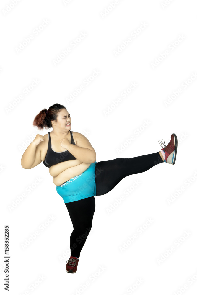 Overweight woman performing a kick