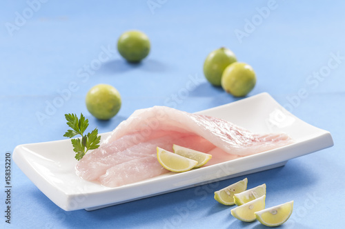 raw white fish fillets with tomatoes and fresh oregano & Lemon slice 