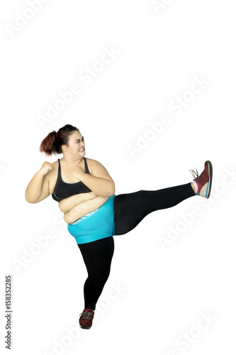 Overweight woman performing a kick
