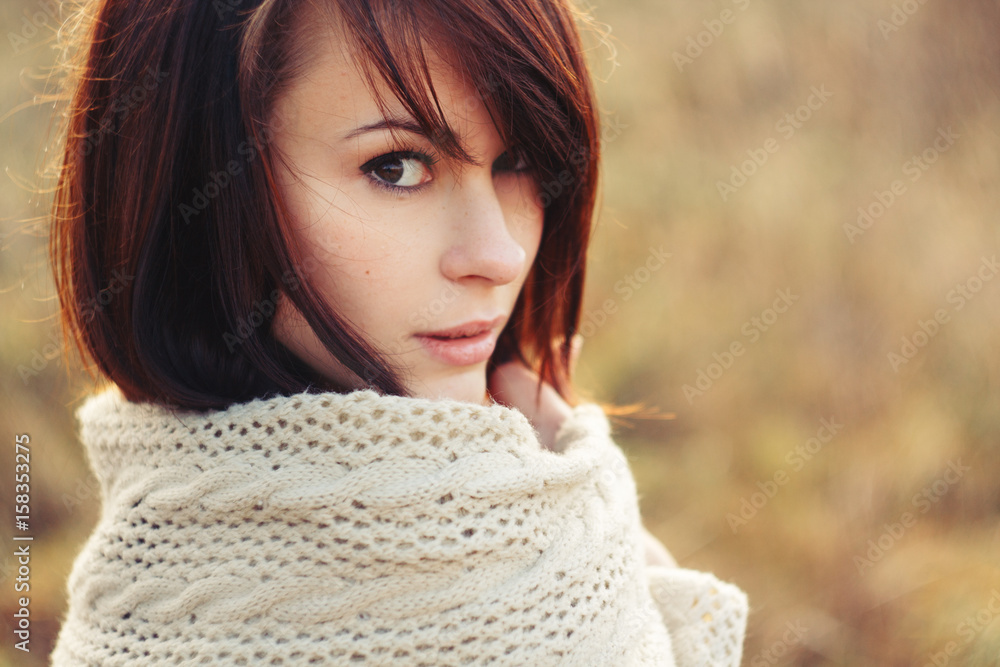 Beautiful brunette in a field freezing with the scarf Beautiful brunette in a field freezing with the scarf