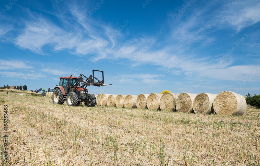Traktor auf einem Feld mit Heuballen
