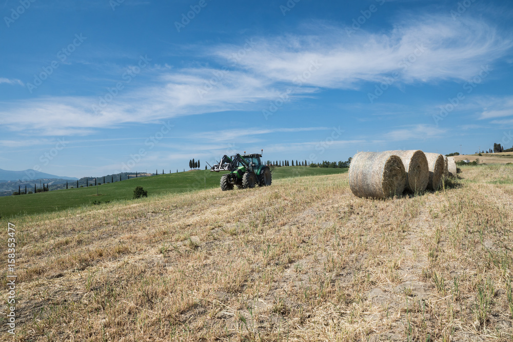 Traktor auf einem Feld mit Heuballen