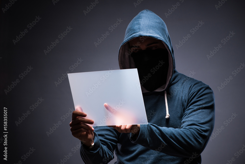 Hacker working on tablet in dark Hacker working on tablet in dark