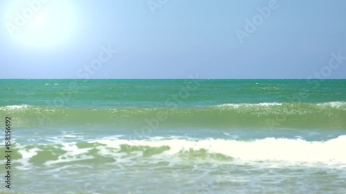 White Crests of Waves Crashing Against a Flat Sandy Beach photo