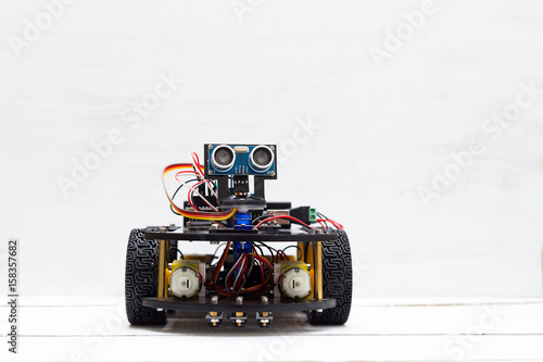 A riding robot on four yellow wheels on a light background