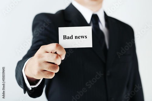 Businessman holding card with word Bad news