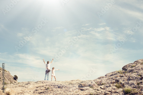 Small girl with father stay on the top of mountain, looking on the beautiful view. Summer concept. Toned image