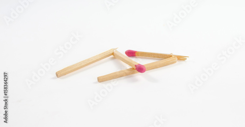 Two broken matches with rose match head on white background