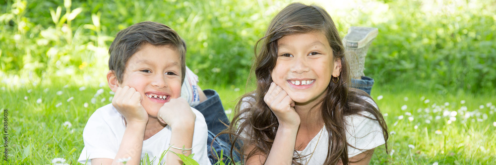 two children boy and girl lying on grass summer two children boy and girl lying on grass summer